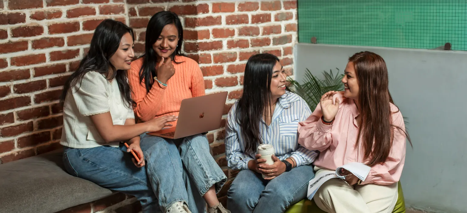 Four female students working in a corridor.